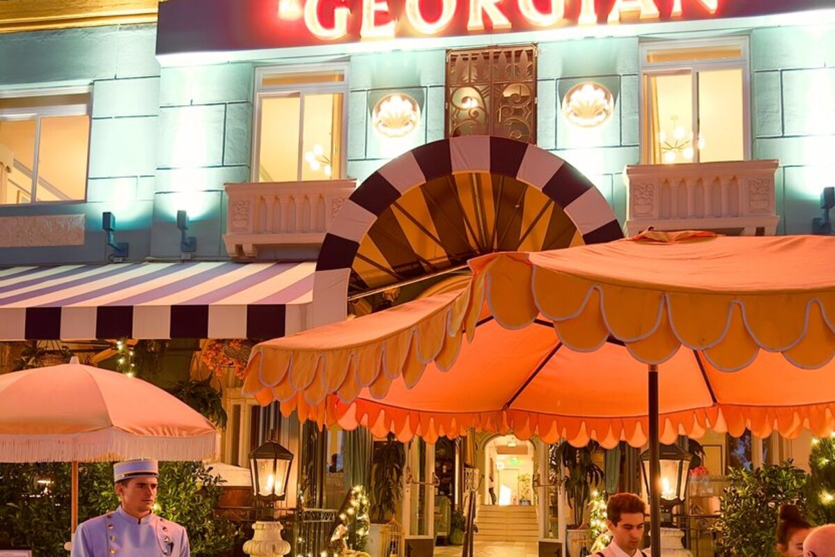 Outside view of the Georgian Hotel with belboy in baby blue uniform.