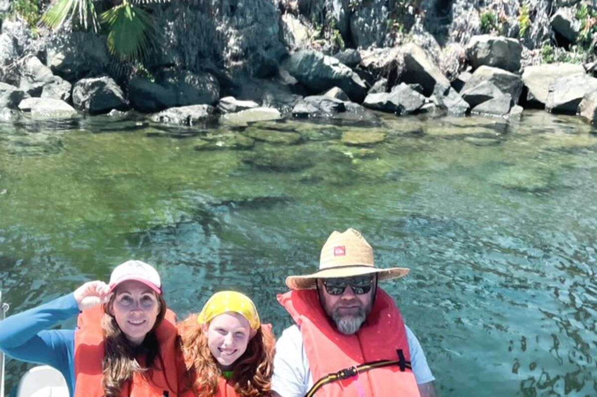 A family of three sitting on a pedal boat in Mission Bay.