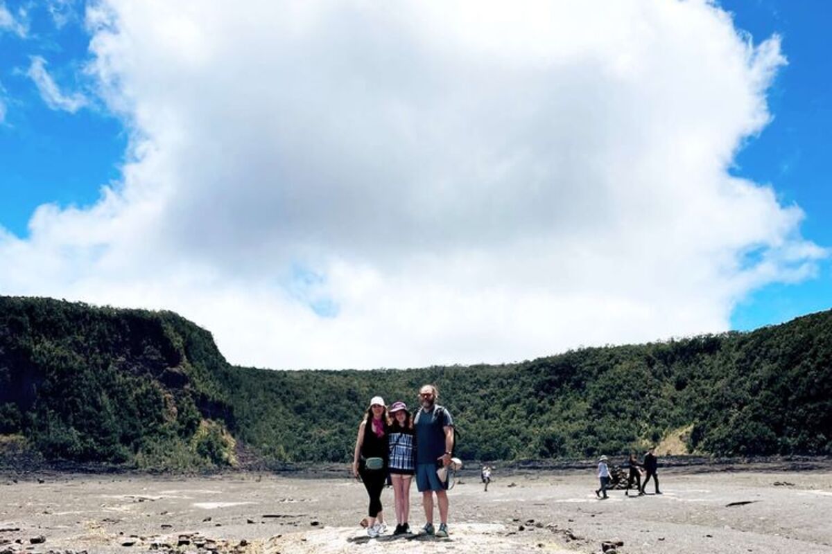 Three people walking through a Volcano caldera in the daytime.