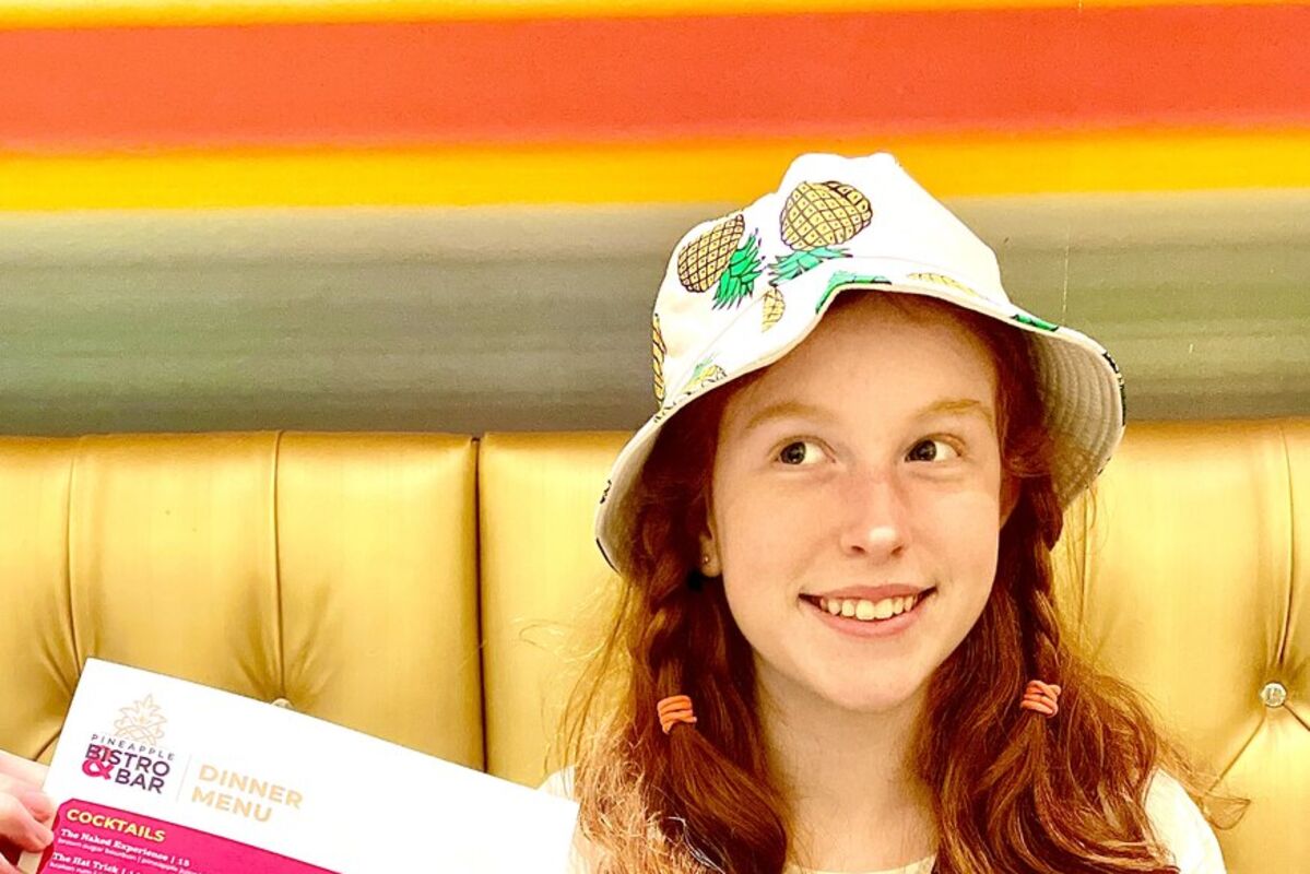 A girl holding the menu for the dining area at The Maxwell Hotel