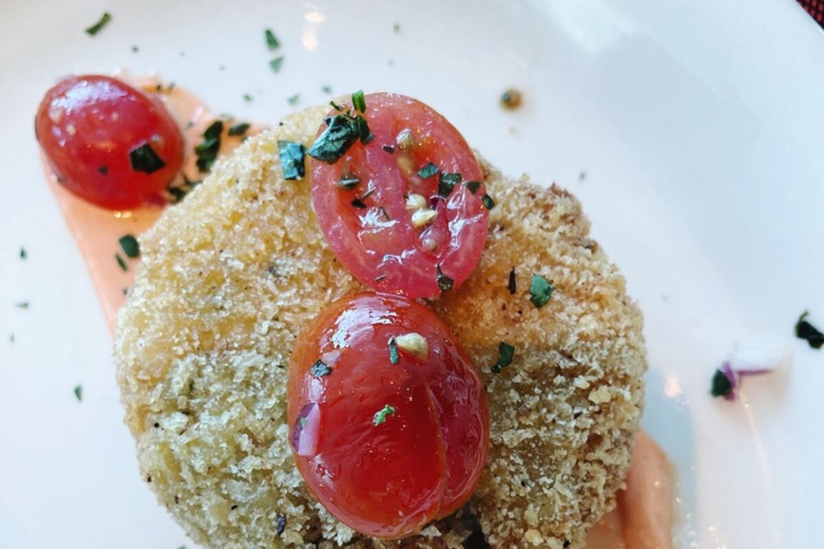 Crab cake with tomatoes and sauce.