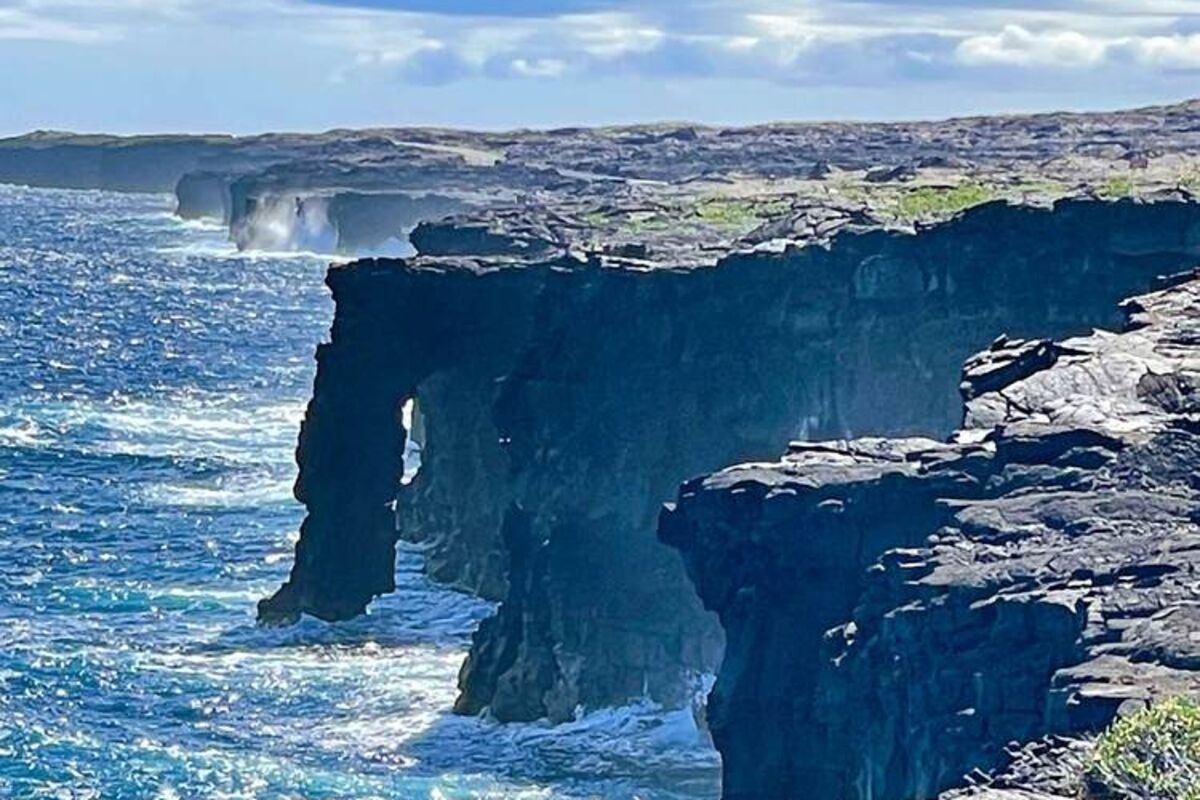 Holei sea arch in Hawaii with crashing waves and rugged cliffs.