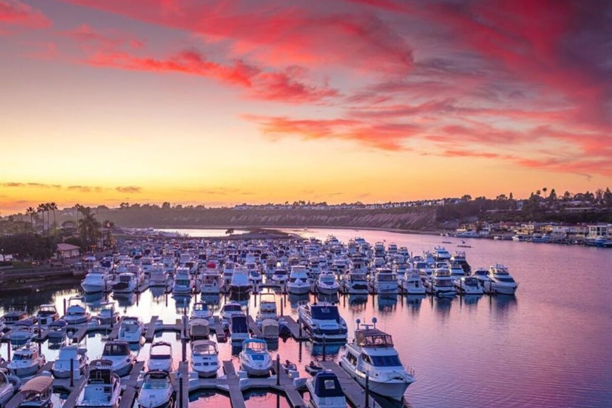 A pink and yellow sunset over the marina full of boats