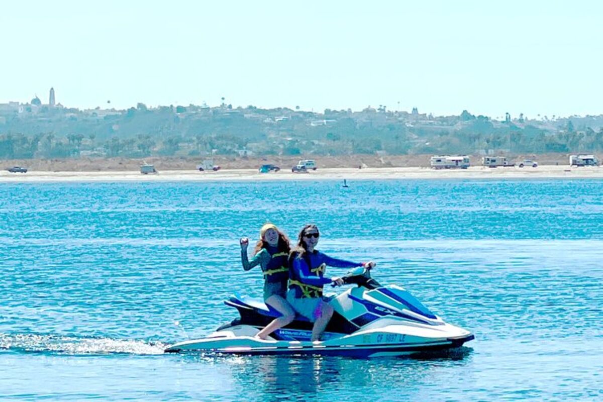 Two girls on a jet ski riding in the water at Campland.