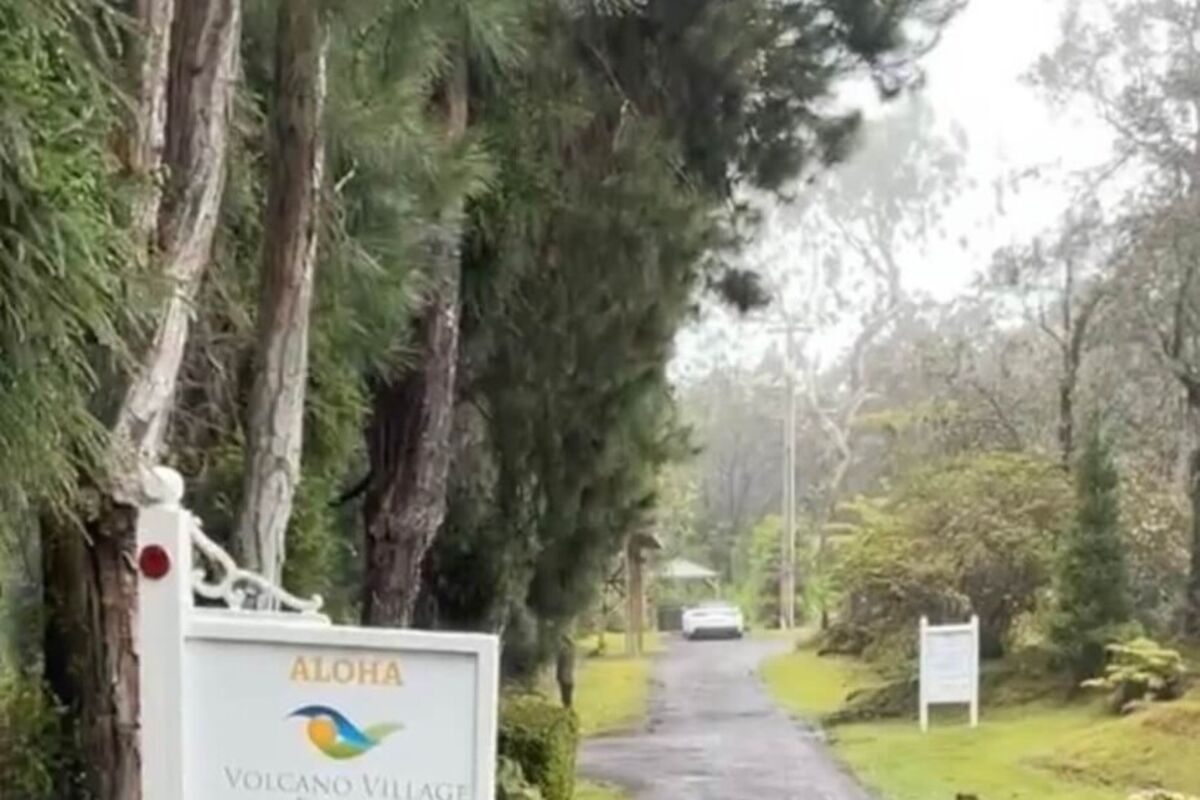 Sign for hotel with long driveway leading to bungalows.